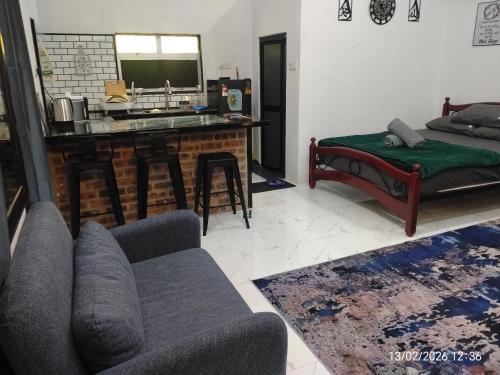 a living room with a couch and a kitchen at Moksu Garden Tiny House jerteh in Jertih