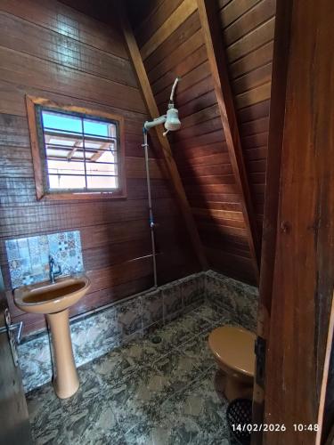 a bathroom with a sink and a toilet at Chalés Caraguatatuba in Caraguatatuba
