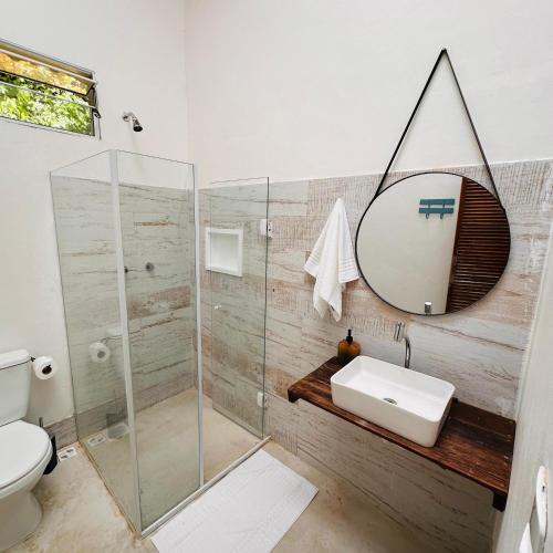 a bathroom with a shower and a sink and a mirror at Refugio Ilha Grande in Angra dos Reis