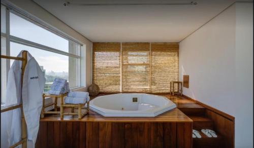 a large bath tub in a room with a large window at Radisson Berrini Suite executiva Luxo Queen in São Paulo