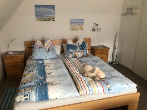 a bed with a stuffed teddy bear sitting on it at Gemütliches Inselnest mit großer Terrasse nahe Nordsee& Hafen in Tönning
