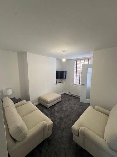 a living room with two couches and a kitchen at 18 Morawel in Burry Port