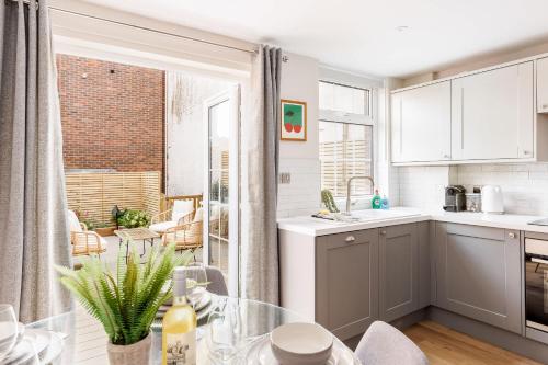 a kitchen with a table and a dining room at Edward Cottage - Old Town Poole Home, Moments from Poole Quay in Poole