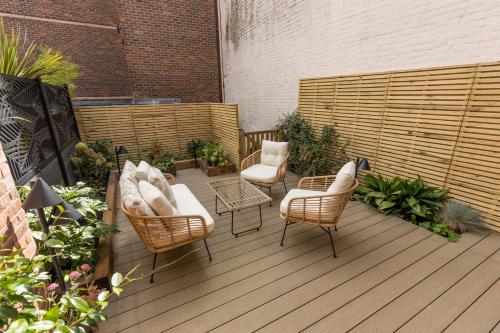 a patio with chairs and tables and a fence at Edward Cottage - Old Town Poole Home, Moments from Poole Quay in Poole