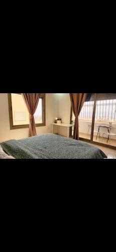 una camera da letto con un letto e una finestra con tende di Qqq2 ad Amman