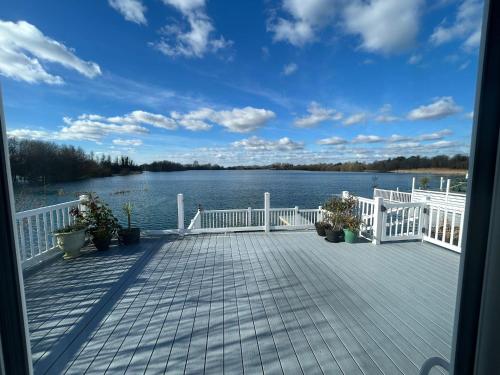 a deck with a view of a body of water at Luxury Lakeview Lodge Chichester Lakeside Holiday Park in Chichester