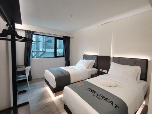 a hotel room with two beds and a window at The Great Hotel Greenhill in Ipoh