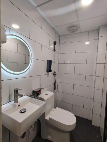 a bathroom with a toilet and a sink and a mirror at The Great Hotel Greenhill in Ipoh