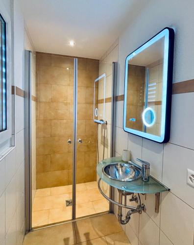 a bathroom with a sink and a shower at Alpine View Thierachern in Thierachern