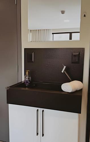a bathroom with a black counter and a sink at Get One - João Pessoa in João Pessoa