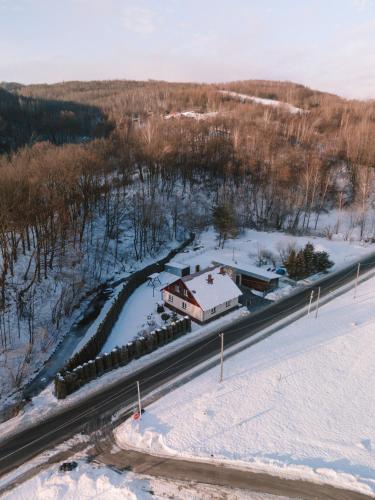 a house on the side of a road in the snow at Domek pod lasem in Kańczuga