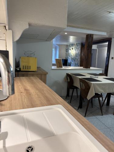 a kitchen and dining room with a sink and a table at Calm guest house in Clerval