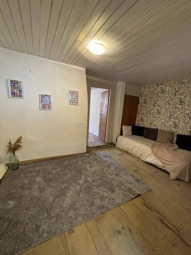 an empty room with a bed and a rug at Calm guest house in Clerval