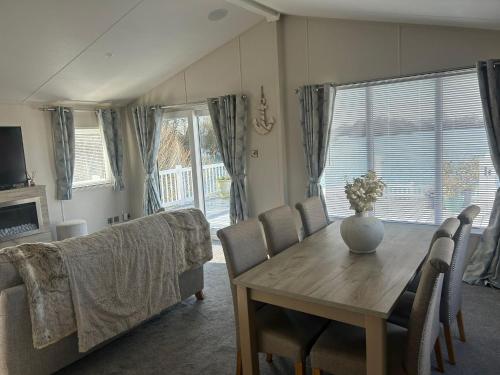 a living room with a table and a couch at Luxury Lakeview Lodge Chichester Lakeside Holiday Park in Chichester