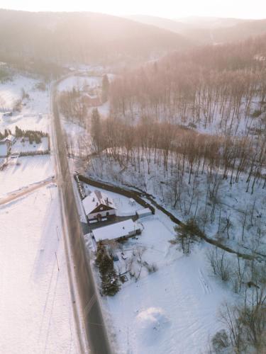 an aerial view of a snowy field with a river at Domek pod lasem in Kańczuga