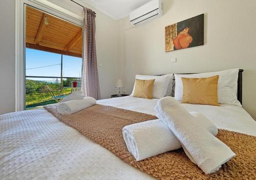 a bedroom with two beds and a large window at Spacious 3bd Apartment in Lefkakia, Nafplio in Levkákia