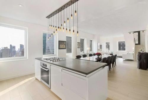 a white kitchen with a stove top island in a room at Cozy 2BD Westminster Apartment in London