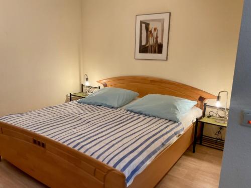 a bedroom with a bed with blue and white striped sheets at Kleine Oase 46 in Funfseen