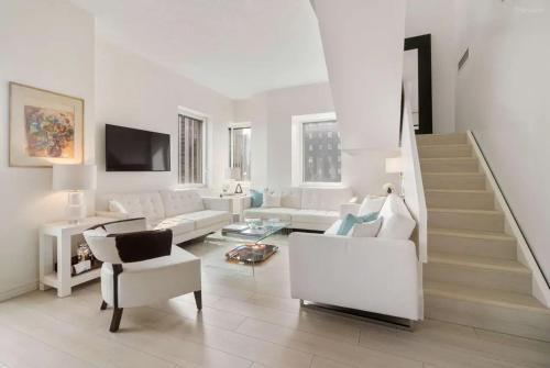 a living room with white furniture and a staircase at Cozy 2BD Westminster Apartment in London
