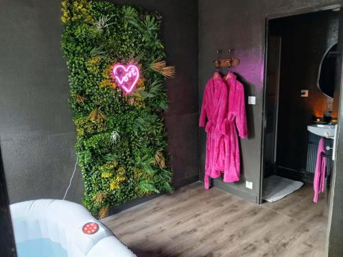 a room with pink clothes hanging on a wall at la penombre spa in Abbeville