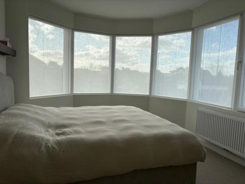 a bedroom with a bed and a bunch of windows at Pirate, op 100 meter van strand in Koksijde