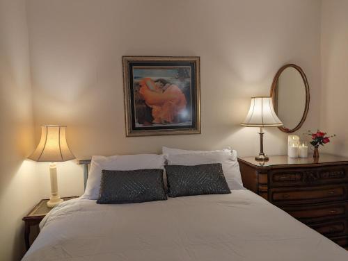 a bedroom with a bed with two lamps and a mirror at Sherlock's Moray House -Idea long stay for contractors & family Two bedroom mid terrace 3 beds 2 sofa beds Sleep 5 Working facility Free WiFi TV & private parking Enclose rear garden dog friendly Sainsbury's & takeaway pubs in walking distance in Church Gresley