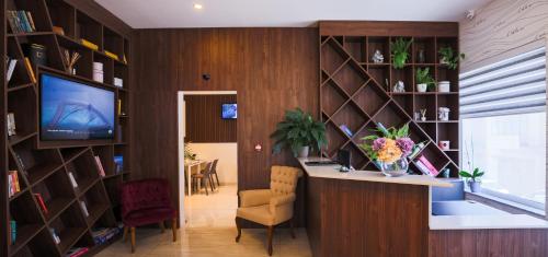 a living room with a desk and a television in a library at C'est La Vie Boutik Swieqi in Is-Swieqi