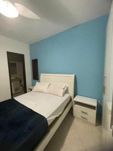 a bedroom with a bed with a blue wall at CAIPORA Hostel Lagoa in Saquarema