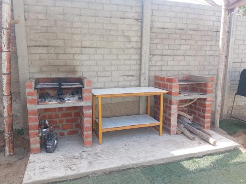 Una pared de ladrillos con una mesa y un horno de ladrillos. en Olas inn, en Asia