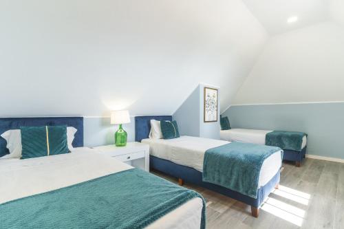 two beds in a room with blue walls at Casa da Horta by Atlantic Holiday in Santa Cruz