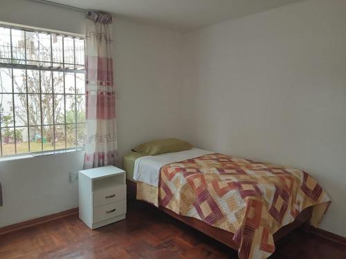 a small bedroom with a bed and a window at KUSIHaus in Lima