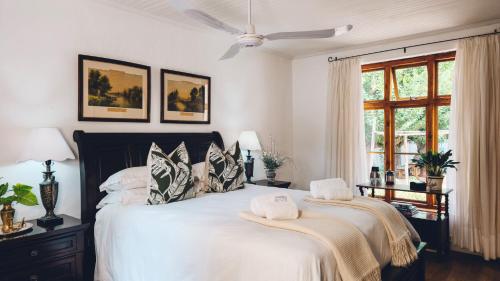 a bedroom with a large bed with two pillows at Cypress Cottage - The Old House at River Bend in Graaff-Reinet