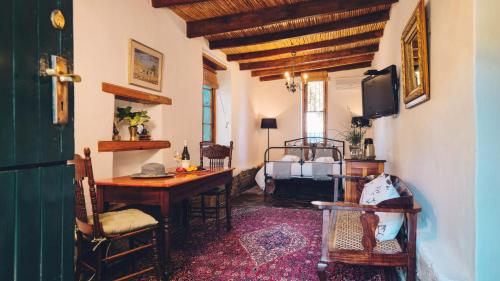 a room with a desk and a tv in a room at Cypress Cottage - The Old House at River Bend in Graaff-Reinet