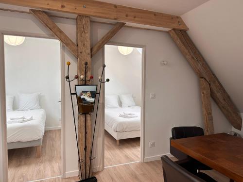 a bedroom with a bed and a mirror and a table at Appartement 2 chambres- 10 mn d'Orléans - Le Nid de la Pointe - in Saint-Pryvé-Saint-Mesmin