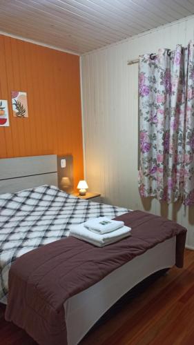 a bedroom with a bed with two towels on it at Chalé Paraíso Da Serra 02 in Gramado