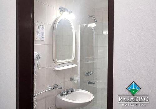a bathroom with a sink and a mirror at Paradiso Hotel & Spa in Merlo
