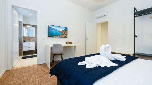 a bedroom with a bed with towel animals on it at Desenzanoloft Garda Golden Sunrise official partner Homes and Villas By Marriott Bonvoy in Desenzano del Garda