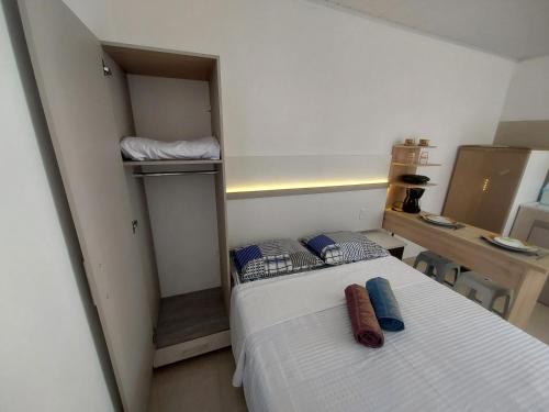 a small bedroom with a bed and a desk at Microcasa loft in São Pedro da Aldeia