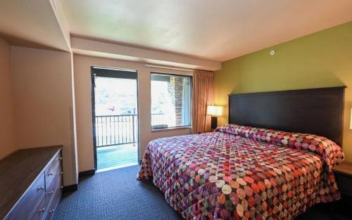 a hotel room with a bed and a large window at Sunset Bay Resort & Suites in Wisconsin Dells