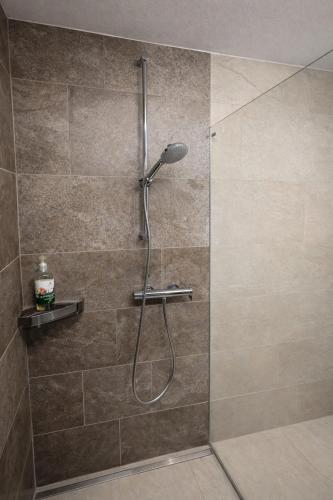 a shower with a shower head in a bathroom at Escala in Fully