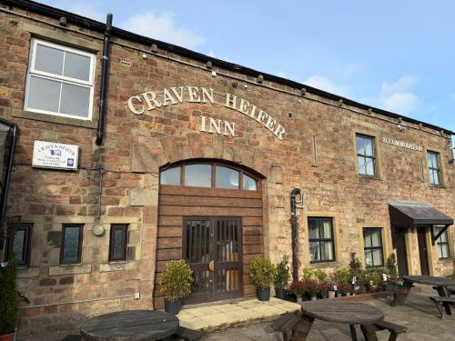 a brick building with a sign that reads canyon heights inn at Craven Heifer in Skipton