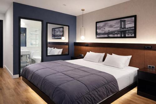 a bedroom with a large bed and a bathroom at Hotel Mirage Brooklyn in Brooklyn