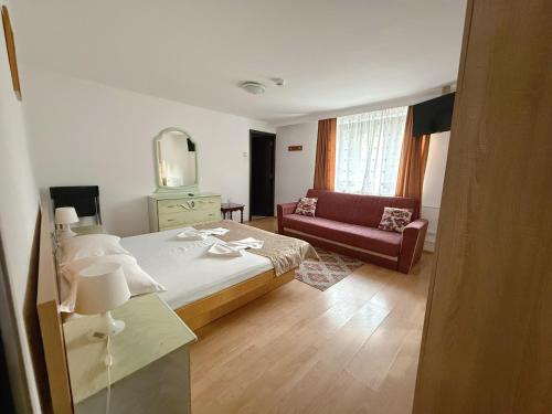 a hotel room with a bed and a couch at Casa Obstei Caciulata in Caciulata
