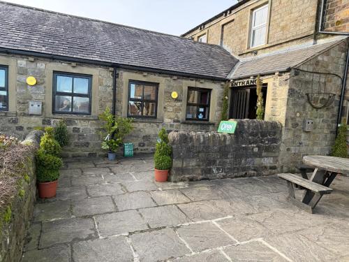 a stone building with a picnic table in front of it at Craven Heifer in Skipton