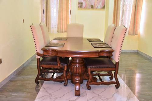 une table en bois avec des chaises et un ordinateur portable dessus dans l'établissement Northern Lights, à Accra