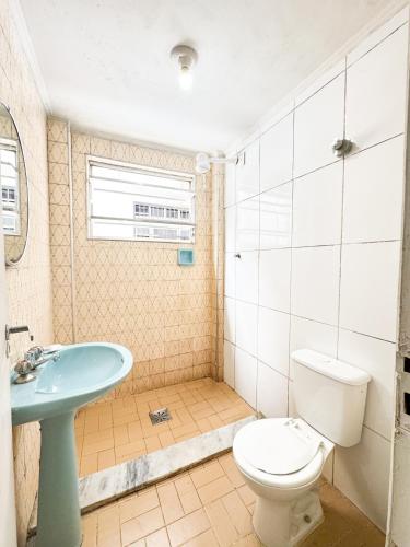 a bathroom with a toilet and a sink at Golfinho Hotel in São Vicente