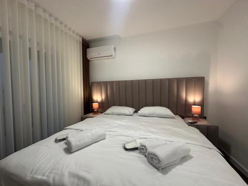 a bedroom with a large white bed with towels on it at Seafront apartment Tivat in Donja Lastva