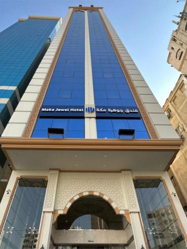 a tall building with a blue sky in the background at جوهرة مكة الفندقية in An Naqāʼ