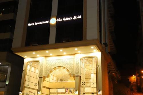 a store front with a lit up sign on a building at جوهرة مكة الفندقية in An Naqāʼ