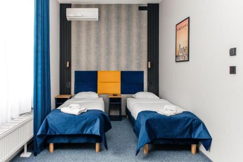 a room with two beds and a desk in it at City Tour Apartamenty in Poznań